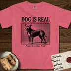 Dog is Real Pitbull T-Shirt flat lay in Watermelon, featuring Black halftone newspaper photo of a broad-chested Pitbull standing in profile with head turned to the camera, under the headline DOG IS REAL, with the caption Praise Be to Dog. Woof..