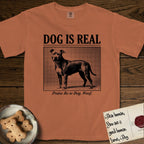 Dog is Real Pitbull T-Shirt flat lay in Yam, featuring Black halftone newspaper photo of a broad-chested Pitbull standing in profile with head turned to the camera, under the headline DOG IS REAL, with the caption Praise Be to Dog. Woof..