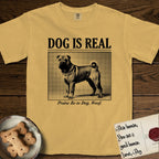 Dog is Real Shar-Pei T-Shirt flat lay in Mustard, featuring Black halftone newspaper photo of a wrinkled Shar-Pei with a curled tail standing in profile with head turned to the camera, under the headline DOG IS REAL, with the caption Praise Be to Dog. Woof..