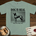 Dog is Real Vizsla T-Shirt flat lay in Bay, featuring Black halftone newspaper photo of a lean Vizsla with long ears standing in profile with head turned to the camera, under the headline DOG IS REAL, with the caption Praise Be to Dog. Woof..