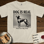 Dog is Real Vizsla T-Shirt flat lay in Ivory, featuring Black halftone newspaper photo of a lean Vizsla with long ears standing in profile with head turned to the camera, under the headline DOG IS REAL, with the caption Praise Be to Dog. Woof..