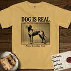 Dog is Real Vizsla T-Shirt flat lay in Mustard, featuring Black halftone newspaper photo of a lean Vizsla with long ears standing in profile with head turned to the camera, under the headline DOG IS REAL, with the caption Praise Be to Dog. Woof..