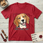 Dog Loves You Beagle T-Shirt flat lay in Cherry Red, featuring Ink and watercolor portrait of a smiling tricolor Beagle with long hanging ears and a cream blaze, head tilted inside a black frame above hand-lettered text reading DOG LOVES YOU.
