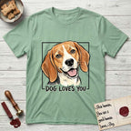 Dog Loves You Beagle T-Shirt flat lay in Mint Green, featuring Ink and watercolor portrait of a smiling tricolor Beagle with long hanging ears and a cream blaze, head tilted inside a black frame above hand-lettered text reading DOG LOVES YOU.