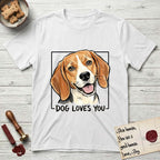 Dog Loves You Beagle T-Shirt flat lay in White, featuring Ink and watercolor portrait of a smiling tricolor Beagle with long hanging ears and a cream blaze, head tilted inside a black frame above hand-lettered text reading DOG LOVES YOU.