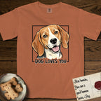 Dog Loves You Beagle T-Shirt flat lay in Yam, featuring Ink and watercolor portrait of a smiling tricolor Beagle with long hanging ears and a cream blaze, head tilted inside a black frame above hand-lettered text reading DOG LOVES YOU.