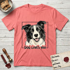 Dog Loves You Border Collie T-Shirt flat lay in Coral Silk, featuring Ink and watercolor portrait of a smiling black and white Border Collie with a cream blaze and semi-erect ears, head tilted inside a black frame above hand-lettered text reading DOG LOVES YOU.