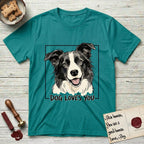 Dog Loves You Border Collie T-Shirt flat lay in Jade Dome, featuring Ink and watercolor portrait of a smiling black and white Border Collie with a cream blaze and semi-erect ears, head tilted inside a black frame above hand-lettered text reading DOG LOVES YOU.