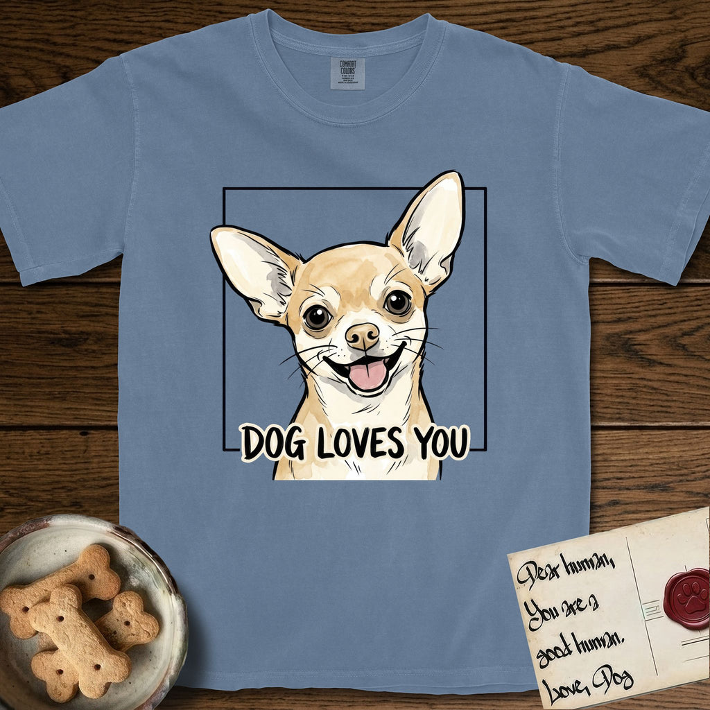 Dog Loves You Chihuahua T-Shirt flat lay in Blue Jean, featuring Ink and watercolor portrait of a smiling fawn Chihuahua with enormous upright bat ears and big round dark eyes, head tilted inside a black frame above hand-lettered text reading DOG LOVES YOU.