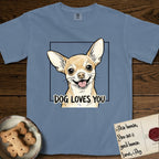 Dog Loves You Chihuahua T-Shirt flat lay in Blue Jean, featuring Ink and watercolor portrait of a smiling fawn Chihuahua with enormous upright bat ears and big round dark eyes, head tilted inside a black frame above hand-lettered text reading DOG LOVES YOU.