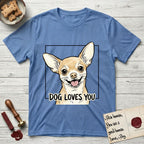 Dog Loves You Chihuahua T-Shirt flat lay in Carolina Blue, featuring Ink and watercolor portrait of a smiling fawn Chihuahua with enormous upright bat ears and big round dark eyes, head tilted inside a black frame above hand-lettered text reading DOG LOVES YOU.