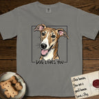 Dog Loves You Galgo T-Shirt flat lay in Grey, featuring Ink and watercolor portrait of a smiling brindle Galgo with a long narrow muzzle and folded rose ears, head tilted inside a black frame above hand-lettered text reading DOG LOVES YOU.