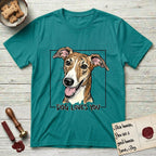 Dog Loves You Galgo T-Shirt flat lay in Jade Dome, featuring Ink and watercolor portrait of a smiling brindle Galgo with a long narrow muzzle and folded rose ears, head tilted inside a black frame above hand-lettered text reading DOG LOVES YOU.