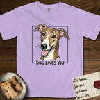Dog Loves You Galgo T-Shirt flat lay in Orchid, featuring Ink and watercolor portrait of a smiling brindle Galgo with a long narrow muzzle and folded rose ears, head tilted inside a black frame above hand-lettered text reading DOG LOVES YOU.