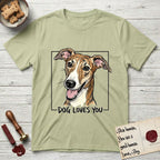 Dog Loves You Galgo T-Shirt flat lay in Pistachio, featuring Ink and watercolor portrait of a smiling brindle Galgo with a long narrow muzzle and folded rose ears, head tilted inside a black frame above hand-lettered text reading DOG LOVES YOU.