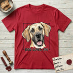Dog Loves You Great Dane T-Shirt flat lay in Cherry Red, featuring Ink and watercolor portrait of a smiling fawn Great Dane with a black mask and natural floppy ears, head tilted inside a black frame above hand-lettered text reading DOG LOVES YOU.