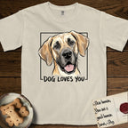 Dog Loves You Great Dane T-Shirt flat lay in Ivory, featuring Ink and watercolor portrait of a smiling fawn Great Dane with a black mask and natural floppy ears, head tilted inside a black frame above hand-lettered text reading DOG LOVES YOU.