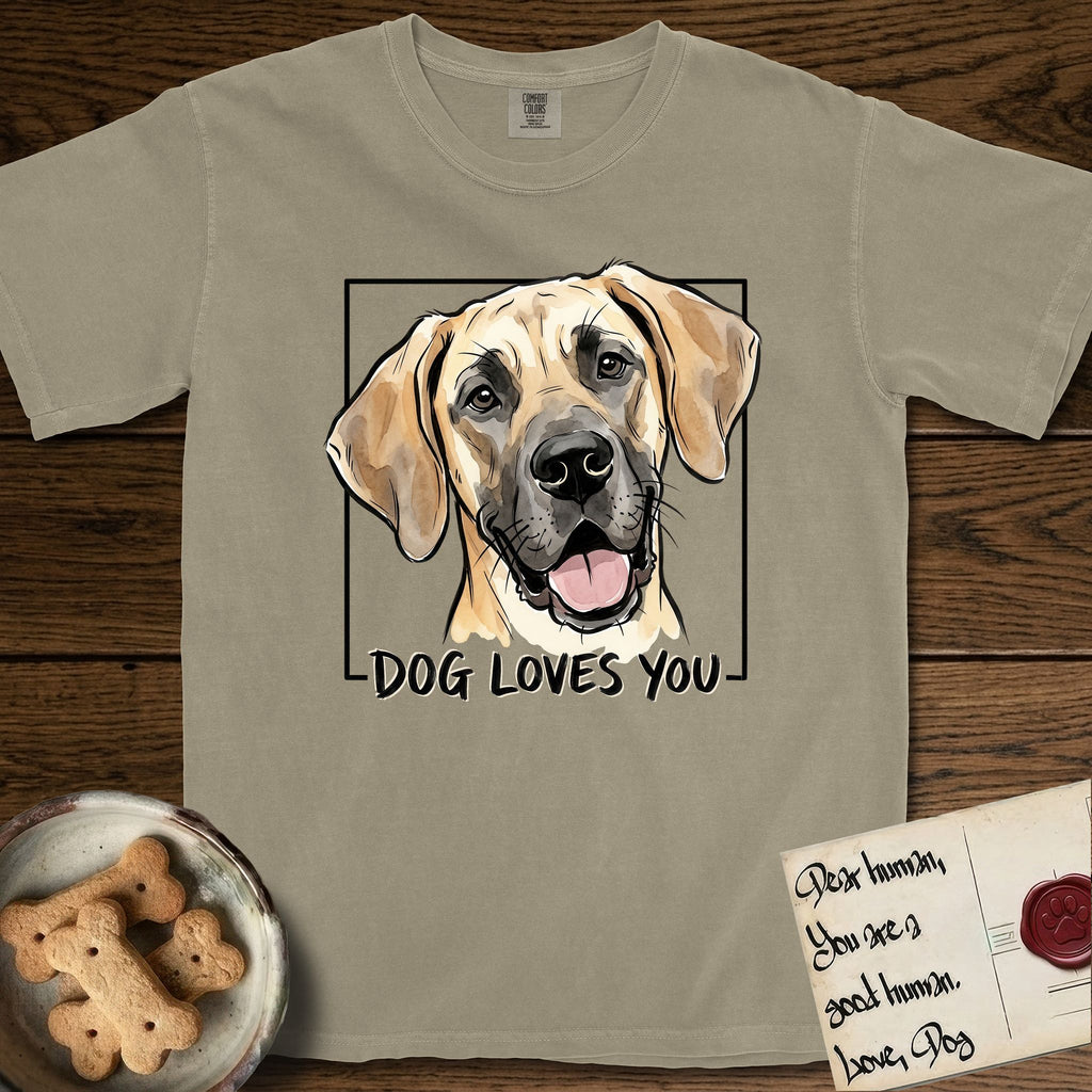 Dog Loves You Great Dane T-Shirt flat lay in Khaki, featuring Ink and watercolor portrait of a smiling fawn Great Dane with a black mask and natural floppy ears, head tilted inside a black frame above hand-lettered text reading DOG LOVES YOU.