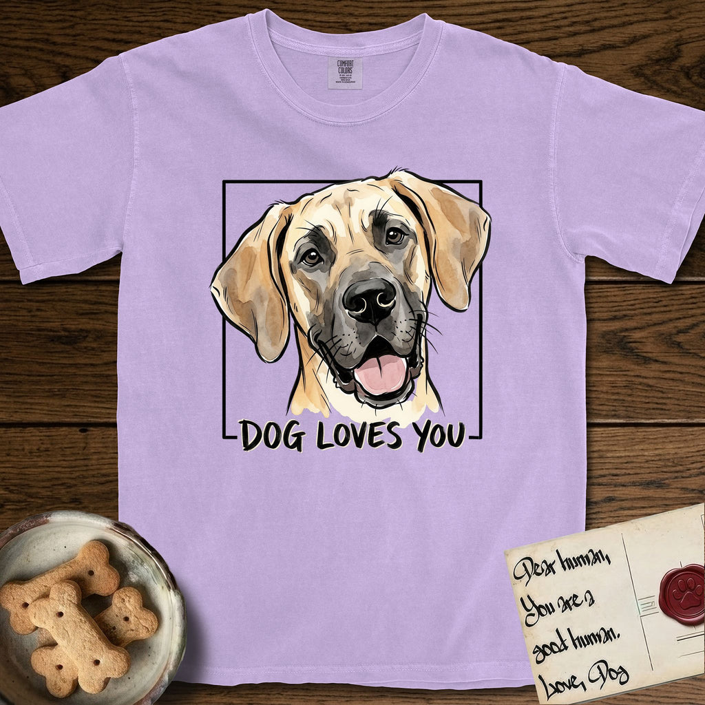 Dog Loves You Great Dane T-Shirt flat lay in Orchid, featuring Ink and watercolor portrait of a smiling fawn Great Dane with a black mask and natural floppy ears, head tilted inside a black frame above hand-lettered text reading DOG LOVES YOU.