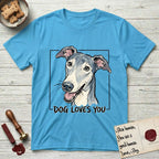 Dog Loves You Greyhound T-Shirt flat lay in Sky, featuring Ink and watercolor portrait of a smiling slate blue Greyhound with a long narrow muzzle, cream blaze and folded rose ears, head tilted inside a black frame above hand-lettered text reading DOG LOVES YOU.