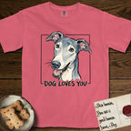 Dog Loves You Greyhound T-Shirt flat lay in Watermelon, featuring Ink and watercolor portrait of a smiling slate blue Greyhound with a long narrow muzzle, cream blaze and folded rose ears, head tilted inside a black frame above hand-lettered text reading DOG LOVES YOU.