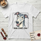 Dog Loves You Greyhound T-Shirt flat lay in White, featuring Ink and watercolor portrait of a smiling slate blue Greyhound with a long narrow muzzle, cream blaze and folded rose ears, head tilted inside a black frame above hand-lettered text reading DOG LOVES YOU.