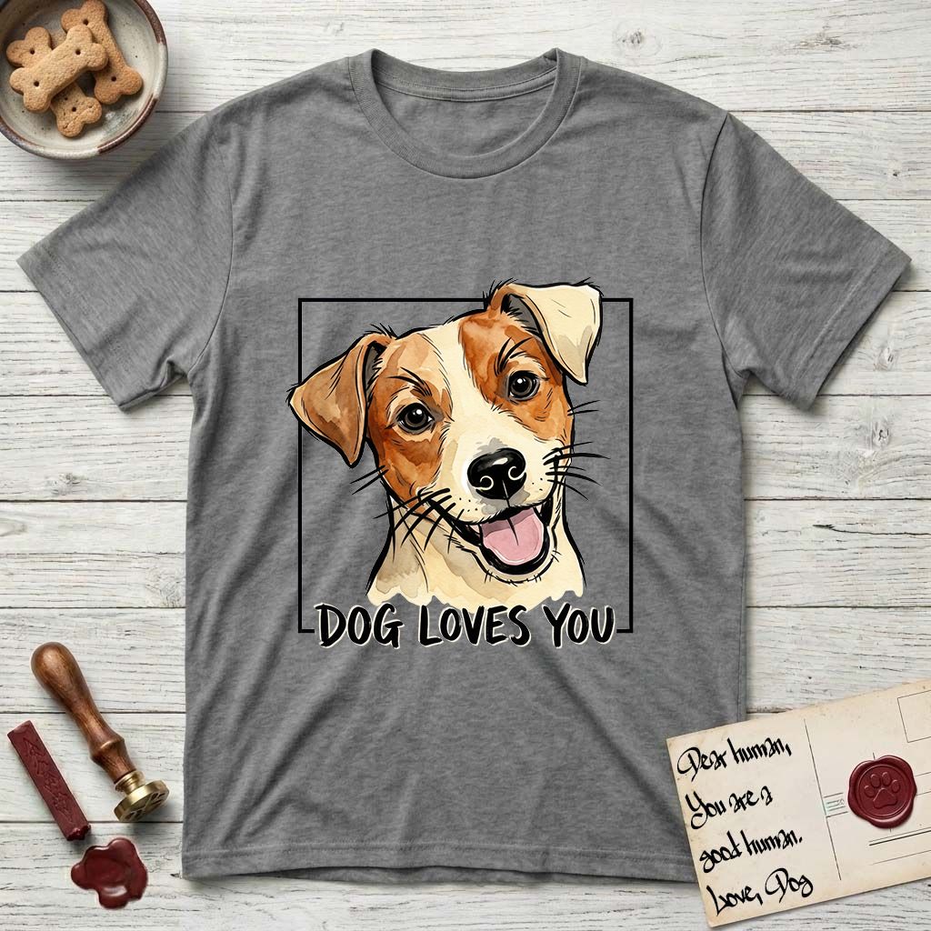 Dog Loves You Jack Russell T-Shirt flat lay in Graphite Heather, featuring Ink and watercolor portrait of a smiling cream and rust Jack Russell with folded button ears and keen dark eyes, head tilted inside a black frame above hand-lettered text reading DOG LOVES YOU.