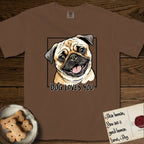 Dog Loves You Pug T-Shirt flat lay in Espresso, featuring Ink and watercolor portrait of a smiling fawn Pug with a black mask, deep brow wrinkles and big round eyes, head tilted inside a black frame above hand-lettered text reading DOG LOVES YOU.