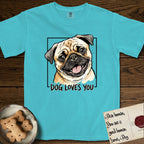 Dog Loves You Pug T-Shirt flat lay in Lagoon Blue, featuring Ink and watercolor portrait of a smiling fawn Pug with a black mask, deep brow wrinkles and big round eyes, head tilted inside a black frame above hand-lettered text reading DOG LOVES YOU.