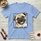 Dog Loves You Pug T-Shirt flat lay in Light Blue, featuring Ink and watercolor portrait of a smiling fawn Pug with a black mask, deep brow wrinkles and big round eyes, head tilted inside a black frame above hand-lettered text reading DOG LOVES YOU.