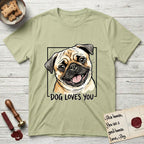 Dog Loves You Pug T-Shirt flat lay in Pistachio, featuring Ink and watercolor portrait of a smiling fawn Pug with a black mask, deep brow wrinkles and big round eyes, head tilted inside a black frame above hand-lettered text reading DOG LOVES YOU.
