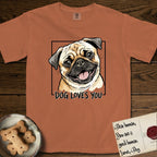 Dog Loves You Pug T-Shirt flat lay in Yam, featuring Ink and watercolor portrait of a smiling fawn Pug with a black mask, deep brow wrinkles and big round eyes, head tilted inside a black frame above hand-lettered text reading DOG LOVES YOU.