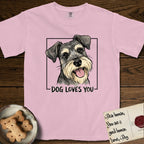Dog Loves You Schnauzer T-Shirt flat lay in Blossom, featuring Ink and watercolor portrait of a smiling salt and pepper Schnauzer with a long beard and bushy eyebrows, head tilted inside a black frame above hand-lettered text reading DOG LOVES YOU.