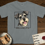 Dog Loves You Schnauzer T-Shirt flat lay in Granite, featuring Ink and watercolor portrait of a smiling salt and pepper Schnauzer with a long beard and bushy eyebrows, head tilted inside a black frame above hand-lettered text reading DOG LOVES YOU.