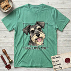 Dog Loves You Schnauzer T-Shirt flat lay in Heather Irish Green, featuring Ink and watercolor portrait of a smiling salt and pepper Schnauzer with a long beard and bushy eyebrows, head tilted inside a black frame above hand-lettered text reading DOG LOVES YOU.