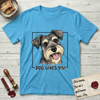 Dog Loves You Schnauzer T-Shirt flat lay in Sky, featuring Ink and watercolor portrait of a smiling salt and pepper Schnauzer with a long beard and bushy eyebrows, head tilted inside a black frame above hand-lettered text reading DOG LOVES YOU.