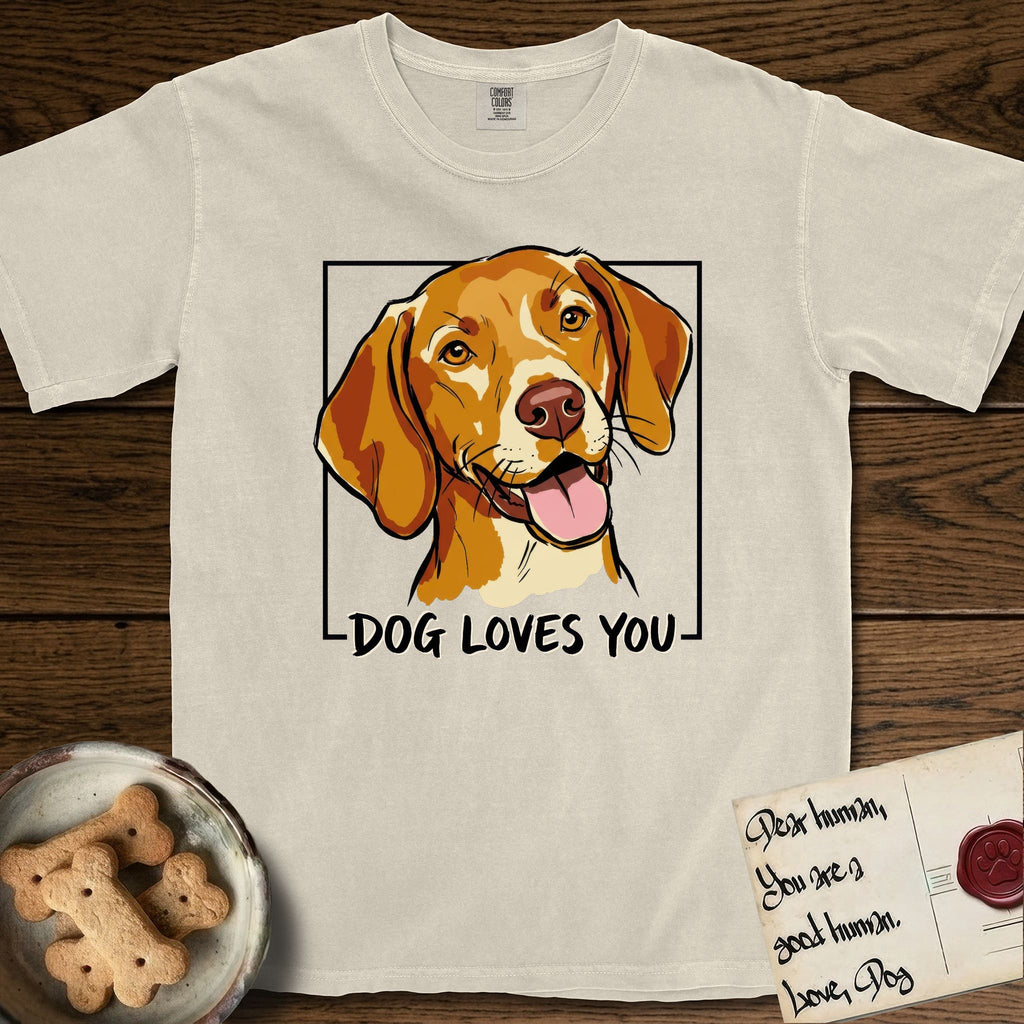 Dog Loves You Vizsla T-Shirt flat lay in Ivory, featuring Ink and watercolor portrait of a smiling golden rust Vizsla with long silky hanging ears and amber eyes, head tilted inside a black frame above hand-lettered text reading DOG LOVES YOU.