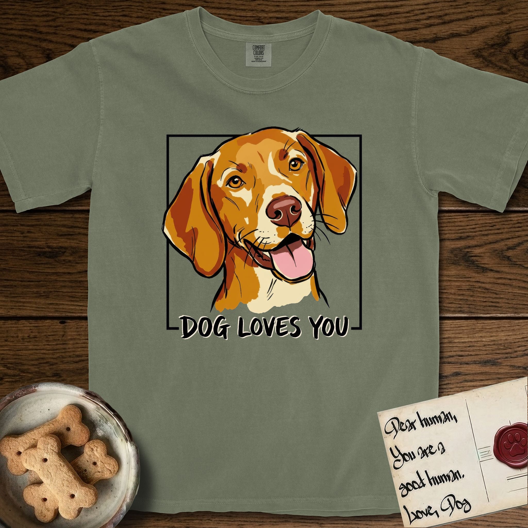 Dog Loves You Vizsla T-Shirt flat lay in Sage, featuring Ink and watercolor portrait of a smiling golden rust Vizsla with long silky hanging ears and amber eyes, head tilted inside a black frame above hand-lettered text reading DOG LOVES YOU.