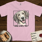 Dog Loves You Weimaraner T-Shirt flat lay in Blossom, featuring Ink and watercolor portrait of a smiling silver grey Weimaraner with long velvet hanging ears and pale amber eyes, head tilted inside a black frame above hand-lettered text reading DOG LOVES YOU.