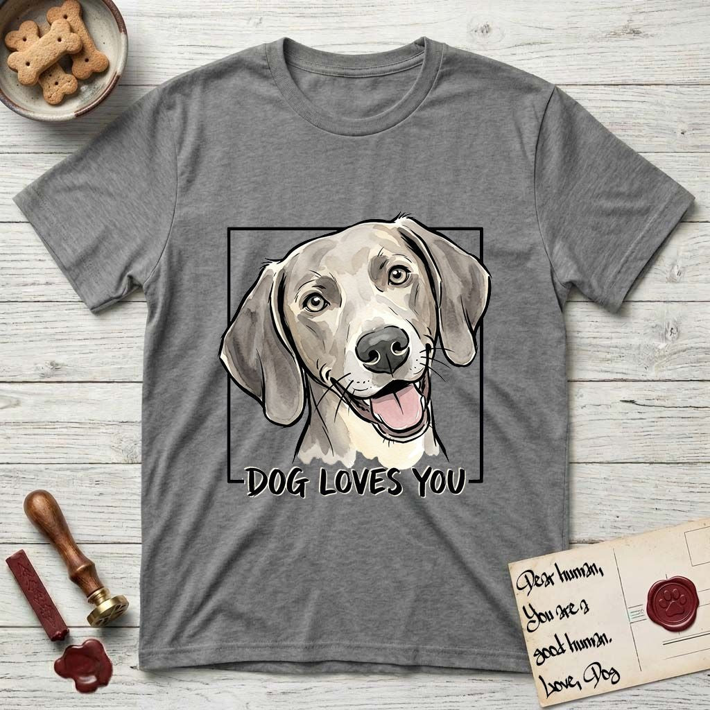 Dog Loves You Weimaraner T-Shirt flat lay in Graphite Heather, featuring Ink and watercolor portrait of a smiling silver grey Weimaraner with long velvet hanging ears and pale amber eyes, head tilted inside a black frame above hand-lettered text reading DOG LOVES YOU.