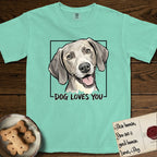 Dog Loves You Weimaraner T-Shirt flat lay in Island Reef, featuring Ink and watercolor portrait of a smiling silver grey Weimaraner with long velvet hanging ears and pale amber eyes, head tilted inside a black frame above hand-lettered text reading DOG LOVES YOU.
