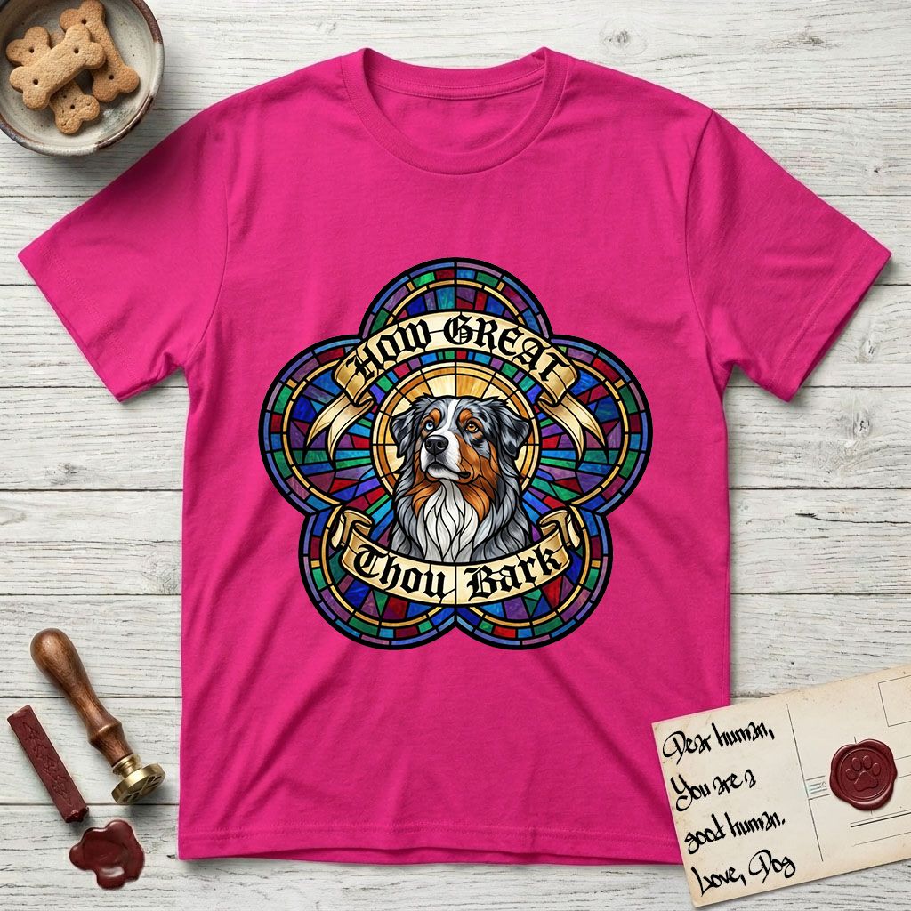 How Great Thou Bark Australian Shepherd T-Shirt flat lay in Heliconia, featuring a full-color stained-glass saint window of a blue merle Australian Shepherd with one blue eye and one amber eye, haloed in golden light.