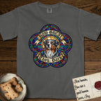 How Great Thou Bark Australian Shepherd T-Shirt flat lay in Pepper, featuring a full-color stained-glass saint window of a blue merle Australian Shepherd with one blue eye and one amber eye, haloed in golden light.