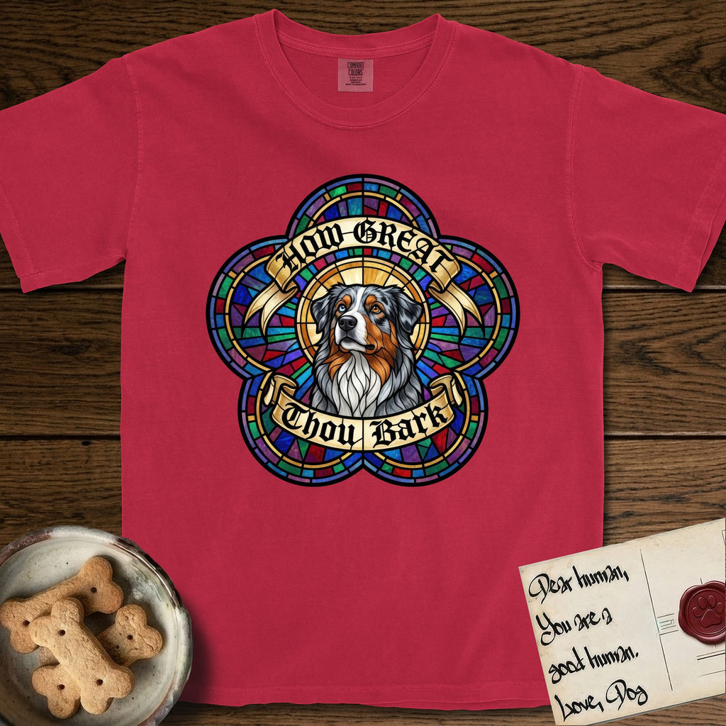 How Great Thou Bark Australian Shepherd T-Shirt flat lay in Red, featuring a full-color stained-glass saint window of a blue merle Australian Shepherd with one blue eye and one amber eye, haloed in golden light.