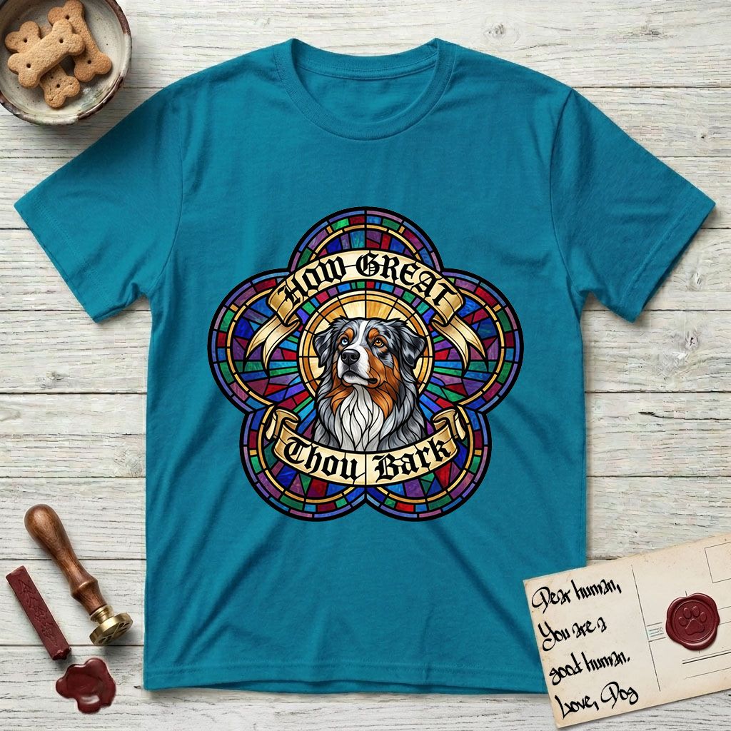 How Great Thou Bark Australian Shepherd T-Shirt flat lay in Tropical Blue, featuring a full-color stained-glass saint window of a blue merle Australian Shepherd with one blue eye and one amber eye, haloed in golden light.