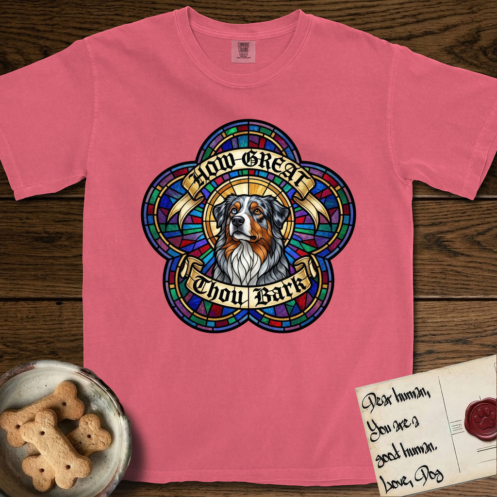 How Great Thou Bark Australian Shepherd T-Shirt flat lay in Watermelon, featuring a full-color stained-glass saint window of a blue merle Australian Shepherd with one blue eye and one amber eye, haloed in golden light.
