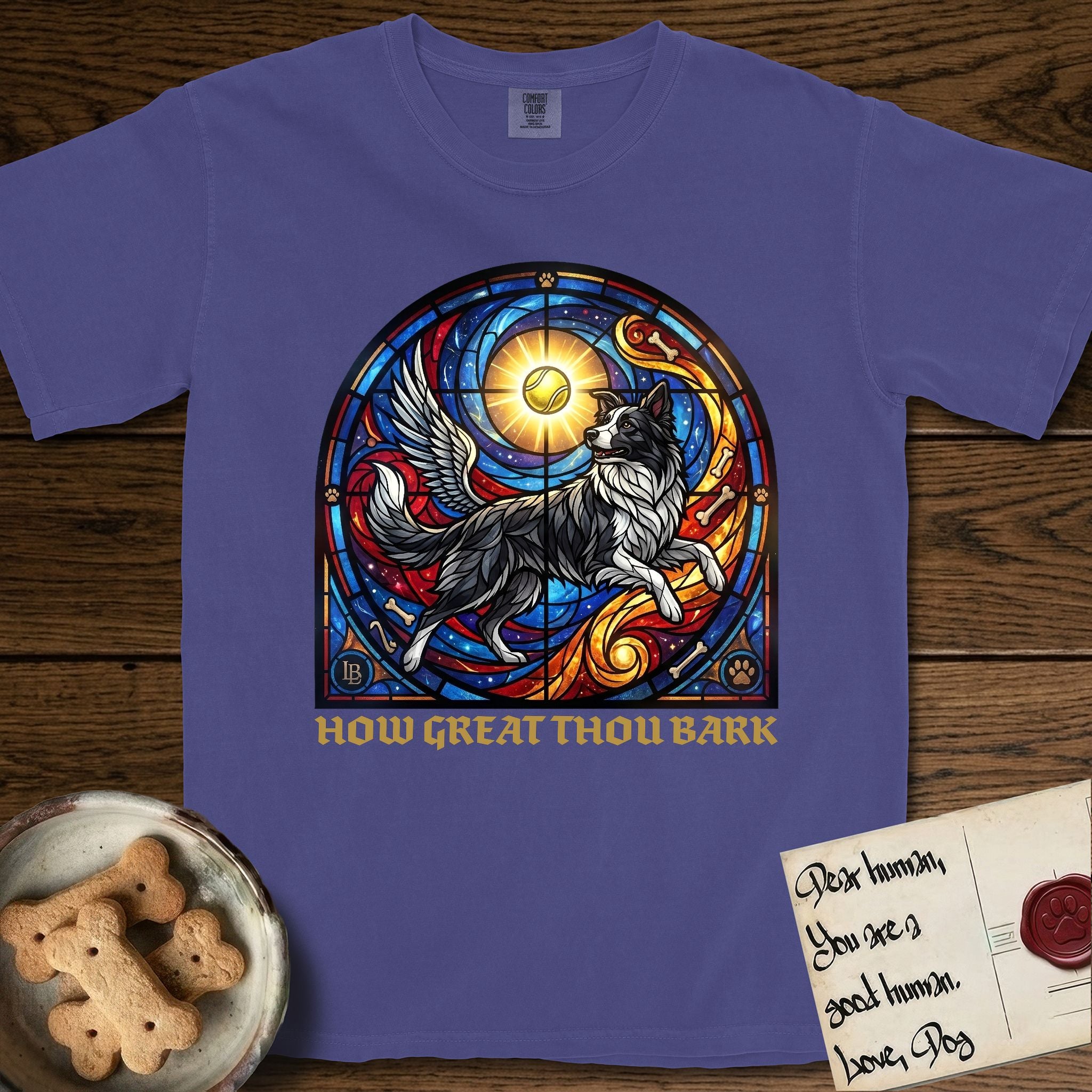 How Great Thou Bark Border Collie T-Shirt flat lay in Grape, featuring a full-color stained-glass saint window of a winged Border Collie leaping after a glowing tennis ball, with a halo.