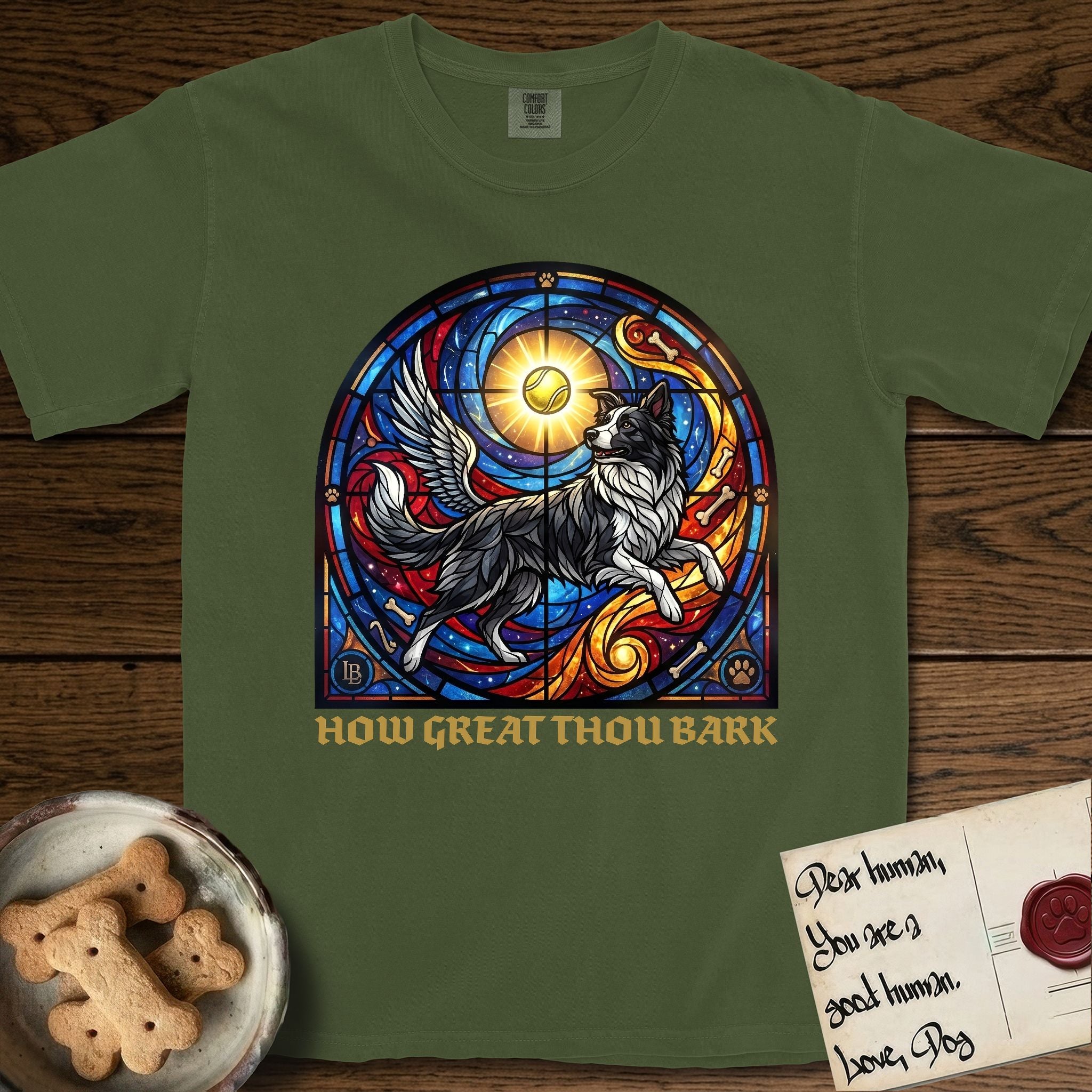 How Great Thou Bark Border Collie T-Shirt flat lay in Hemp, featuring a full-color stained-glass saint window of a winged Border Collie leaping after a glowing tennis ball, with a halo.
