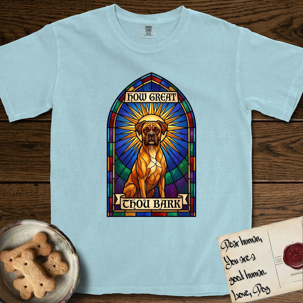 How Great Thou Bark Boxer T-Shirt flat lay in Chambray, featuring a full-color stained-glass saint window of a Boxer seated in warm golden light with a halo.