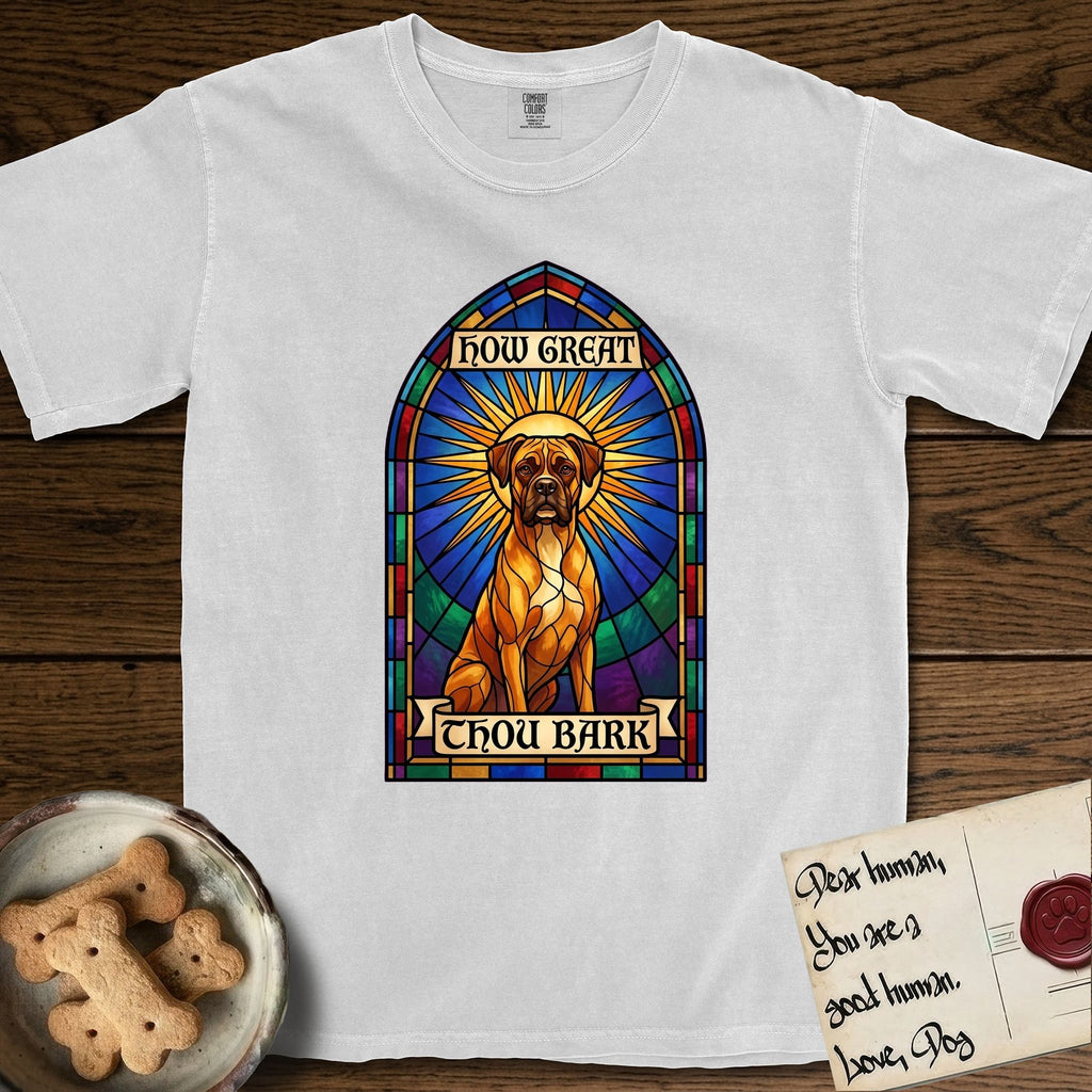 How Great Thou Bark Boxer T-Shirt flat lay in White, featuring a full-color stained-glass saint window of a Boxer seated in warm golden light with a halo.